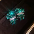 Primer plano de pendientes de racimo marquesa verde esmeralda en un joyero de lujo - Estilo de poste de pendiente de plata / Verde