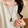 Detailed view of a Mori style handmade acorn pendant necklace on a linen garment. - Acorn Style (1#) / Brown