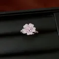 Close-up detail of a luxury flower ring with pink zircons on black leather box - Ring / Silver-Pink