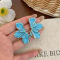 Detailed view of oversized blue enamel petal earrings featuring elegant gold metallic trim - 925 Silver Post Style / Blue