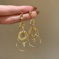 Elegant minimalist gold dangling earrings with knotted top and multiple circular rings - Twist Knot Geometric Multi-Ring Layered Style / 7# Silver Needle - Gold