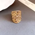 Close-up of a high-end gold plated wide band ring with delicate 3D floral cutout design - 3D Hollow Flower Wide Ring / Gold