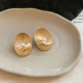 Macro view of gold oval earrings with textured radial pattern and central pearl - Gold Radial Wave Artificial Pearl Style (5#)