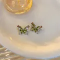 Orecchini a perno a farfalla con cristalli verdi e dettagli di perni in ago d'argento - Argento/Verde