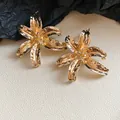 Close-up detail of large gold flower stud earrings with a hammered metal finish. - Gold Large Hammered Texture Flower (17#)