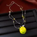 Detailaufnahme einer silbernen Halskette mit grünem Apfelanhänger und gelben Perlen. - Doppellagige Halskette / Halskette - Silber - Grün