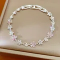 Vue macro détaillée montrant les élégantes fleurs en zircon et perles sur un bracelet argenté - Argent-Rose