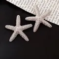 Detailed macro view of silver-toned starfish ear studs with textured zircon pavé. - Silver Starfish Dense Dotted Texture (20#)