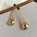 Detail shot of vintage gold-tone earrings with black studs and keyhole pendant - Gold Black Long Lock Teardrop Design (24#)
