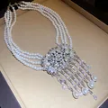 Detail view of a multi-layer pearl necklace featuring crystal accents and teardrop tassels - Necklace / Silver-White