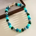 Macro detail of marbled acrylic beads in vibrant blue and green with gold accents - Green Blue Marble