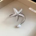 Detailed view of a silver textured starfish arm ring with an elegant pearl accent. - Starfish Pearl / Silver