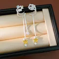 Detailed view of silver star clip-on earrings with yellow zircon and layered tassels - Star Tassel Ear Cuff (HE34077) / Silver-Yellow