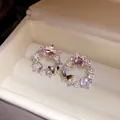 Close-up detail of elegant 18k gold plated butterfly star earrings with pearls and zirconia - Silver