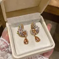 Close-up of vintage gold zircon earrings with amber square and pear drop stones - Gold (Champagne Main Stone)