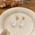 Close-up view of elegant French vintage gold earrings featuring unique irregular baroque pearls - Small / Gold