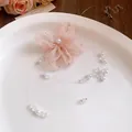 Close-up view of a light pink chiffon flower necklace with elegant pearl beads and crystals - Pink