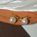 Close-up of minimalist gold-tone stud earrings with white pearl and zircon detail - Pearl Rhinestone Style (HE33401) / Gold-White (Silver Earring Post)