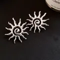 Elegant vintage silver sunburst swirl stud earrings displayed on black textured fabric - Silver Sun Spiral Design Style (65#)