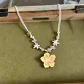 Detail of handmade colorful floral necklace with yellow pendant and star beads - Yellow