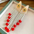 Exquisite detail of resin pearl tassel earrings featuring bright red heart-shaped charms - Silver Post-Gold-White-Red
