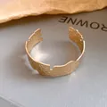 Close-up detail of a minimalist textured gold open cuff bracelet with an irregular design - Crumpled Texture Open Style (HB4686) / Gold