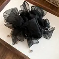 Détail d'un chouchou élégant en mousseline noire avec des breloques en cristal fin - Noir
