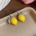 Close-up detail of micro-set zircon lemon charms featuring a vibrant yellow finish - Stud Earrings / Silver Needle / Yellow