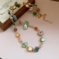 Dettaglio di una collana vintage con perle di conchiglia irregolari e cristalli luce - Marrone