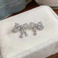 Close-up of elegant bow-knot stud earrings with sparkling zircon stones - Zirconia Pave Bowknot Pendant Style / Silver