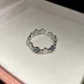 Gros plan d'une bague réglable en argent avec motifs de fleurs en zircon bleu incrustés. - Forme de Fleur à Quatre Feuilles / Argent