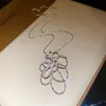 Primo piano del ciondolo a fiore in zirconia scintillante su una collana d'argento - Collana (HN12147) / Argento