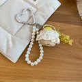 Detailed close-up of a French style pearl beaded keychain with a mini lace straw basket charm - Silver White Green