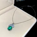 Vista dettagliata di una collana vintage con pendente smeraldo e piuma di zirconi - Collana / Verde
