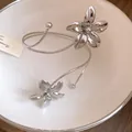 Detail shot of silver metal floral open bangle with polished finish and minimalist design. - Arm Cuff / Silver
