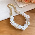 Detailed view of elegant white acrylic flower and golden beaded necklace for resort style - White