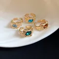 Detailed close-up of vintage irregular crinkled gold rings with colorful inlaid gemstones - Set of 4 / Gold