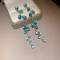 Eleganti orecchini a foglia placcati in oro con zirconi blu a goccia su una scatola - Blu