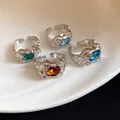Close-up of four vintage irregular wrinkled open rings with colorful gemstones on a plate. - Set of 4 / Silver