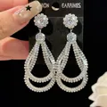 Detailed macro view of luxurious teardrop-shaped zirconia earrings on black display card - Silver Post - Teardrop Shape (HE33442) / Silver