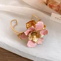 Detailed macro view of a vintage gold metal flower cuff bracelet with pink enamel petals - Bangle / Eco Gold / Pink