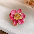 Close-up detail of vintage pink enamel flower earring with golden metallic center petals - Ring / Eco Gold / Rose Red