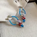 Macro detail of cute mushroom and flower charms on retro blue beaded hoop earrings - Red Blue Mushroom Flower Style / Red Blue