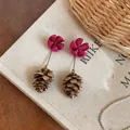 Detail shot of magenta flower and pinecone dangle earrings on a neutral background - Rose Red and Coffee