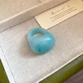 Detail shot of a minimalist blue marbled resin ring with a smooth polished finish. - Light Blue