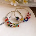 Close-up detail of colorful crystal beaded hoop earrings with gold-tone finish. - Large / Colorful