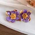 Vintage purple enamel flower stud earrings with gold-tone centers on soft background - Stud Earrings / Purple