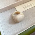 Macro detail of minimalist creamy resin ring featuring an elegant marble swirled texture - Beige