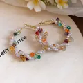Close-up of colorful crystal and pearl beaded hoop earrings on a wooden background - Small / Colorful