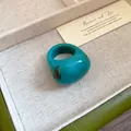 Macro view of a chunky teal resin ring with a unique marbled swirl pattern - Dark Blue